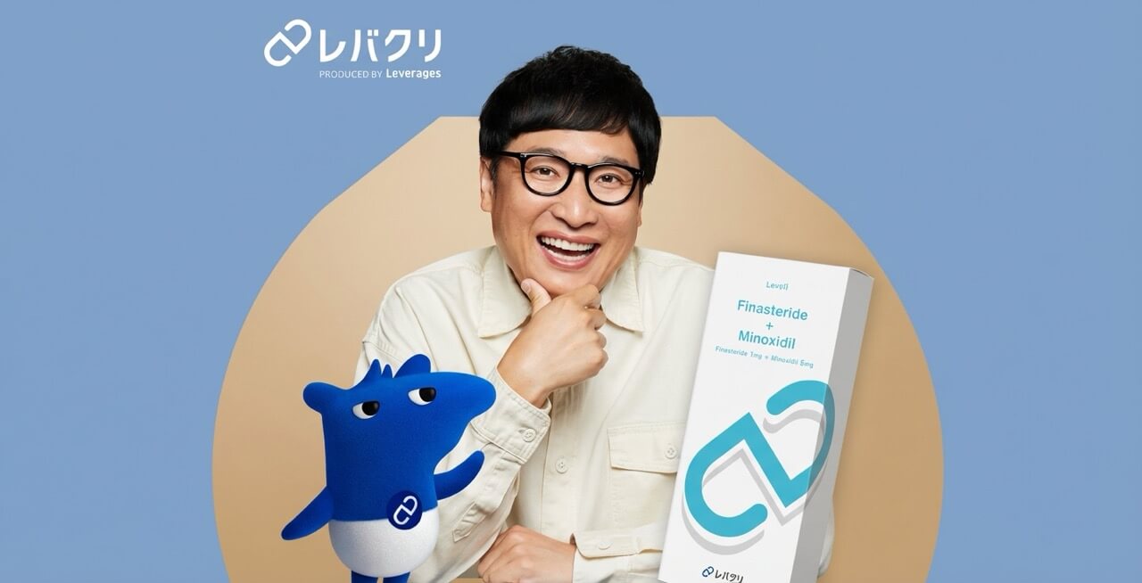 	レバクリのAGA治療薬を持つ笑顔の男性とマスコットキャラクター。製品パッケージにはFinasteride + Minoxidilと表示されている