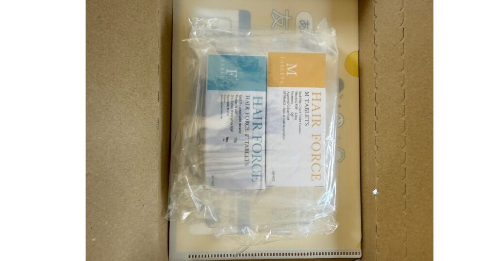 DMMオンラインクリニックから届いたHAIR FORCE F（フィナステリド・青ラベル）とM（ミノキシジル・黄ラベル）の箱を並べた写真
